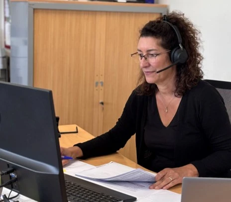 collaboratrice assurant le support technique et le conseil client depuis un poste de travail professionnel