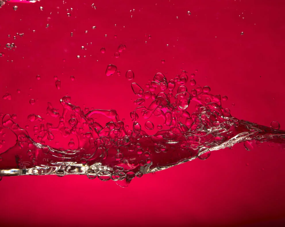 mouvement de liquide clair sur fond rouge illustrant un carburant en action