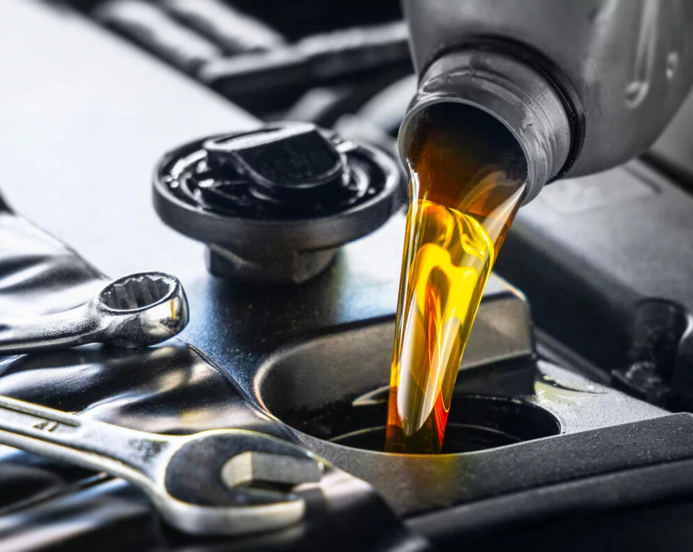 lubrifiant versé dans un moteur lors d’une opération de maintenance professionnelle