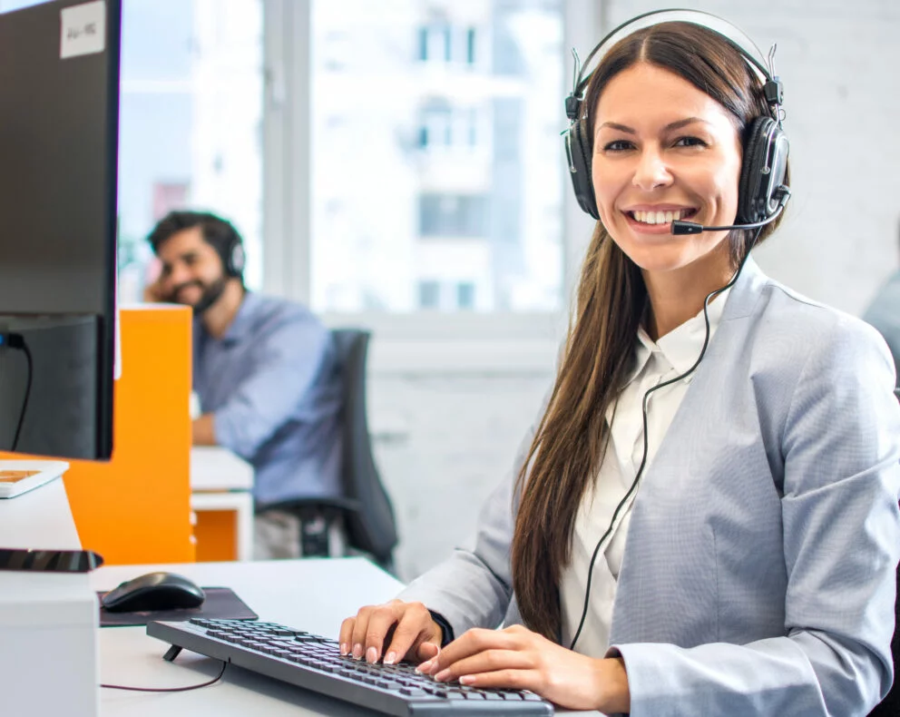 Opérateur au poste informatique avec casque assurant le suivi et l’assistance pour services professionnels.